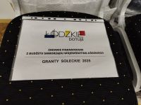 krzesło tapicerowane z metalową ramą z umieszczoną informacją o dofinansowaniu projektu