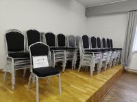 krzesła tapicerowane z metalową ramą ustawione na scenie z informacją o dofinansowaniu projektu